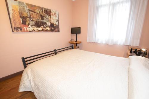 a bedroom with a white bed and a window at Residence La Fenice in Padova