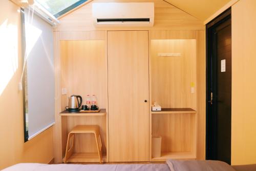 um pequeno quarto com um armário de madeira e uma cama em Bobocabin Madasari, Pangandaran em Bulakbenda