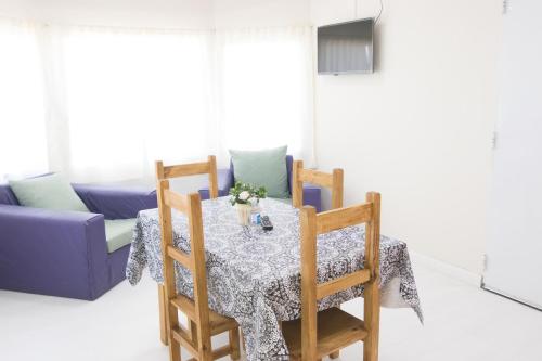 a dining room table with two chairs and a couch at Apartamentos Matices in El Calafate