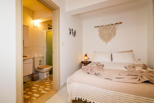 a white bedroom with a bed and a bathroom at Oase Garden Hotel in Cıralı