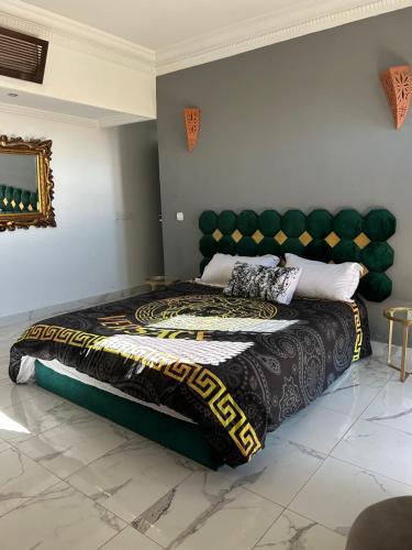 sypialnia z dużym łóżkiem z zielonym zagłówkiem w obiekcie Villa Madina w mieście Dar Caïd Layadi