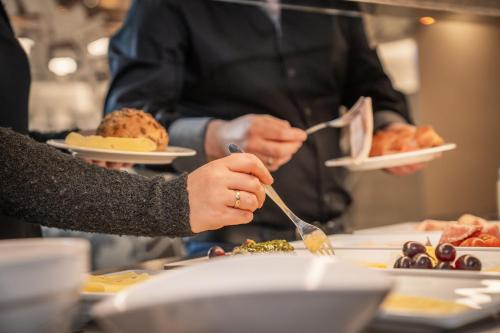 a person holding a plate of food on a table at Genusshotel "Zum Wendl" in Freyung