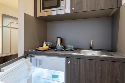 a kitchen with a sink and a microwave at ibis Styles Bielefeld City in Bielefeld