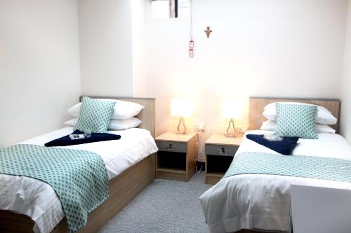 a bedroom with two beds and two night stands at Theodore House in Clitheroe