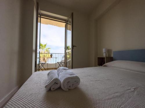 1 dormitorio con 1 cama con toallas en Caronì - Casa Sul Mare, en Caronia Marina