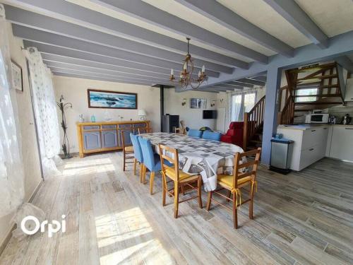 une salle à manger et une cuisine avec une table et des chaises dans l'établissement Ref 022 - Grande maison pour dix personnes avec jardin et palmier, à Arzon