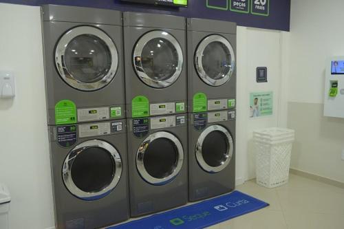 a row of washing machines in a laundry room at Hotel Skalla - MELHOR CUSTO BENEFICIO in Teixeira de Freitas