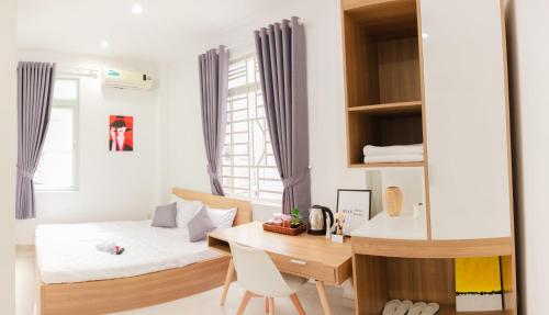 a bedroom with a bed and a desk and a table at Hello SaiGon Homestay in Ho Chi Minh City