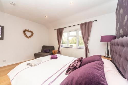 a bedroom with a bed and a chair and a window at 6 bedrooms beautiful home 3 bathrooms, quiet location with garden near Legoland Windsor Heathrow in Maidenhead