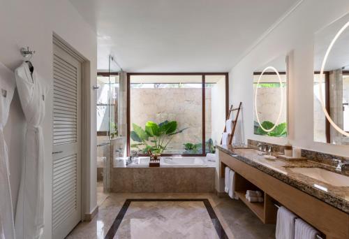 a bathroom with a tub and a sink and a shower at Fairmont Mayakoba in Playa del Carmen
