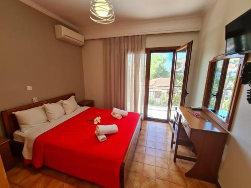 a bedroom with a red bed with towels on it at Zigos Apartments in Igoumenitsa