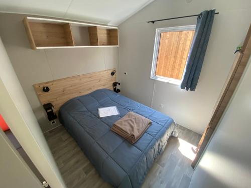 a small room with a blue bed in it at Camping Le Repos in Saint-Palais-sur-Mer