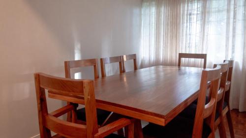 a dining room table with four chairs and a wooden table at Andrella Home Arusha in Arusha