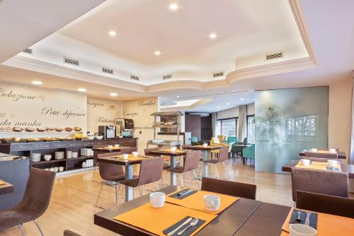 Un restaurante con mesas y sillas y una cafetería. en Acta Antibes, en Barcelona