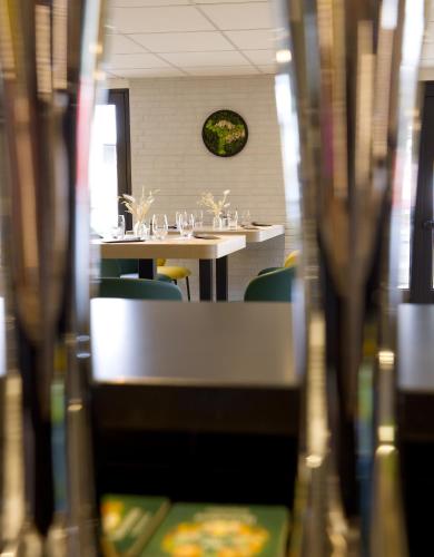 a room with tables and chairs and a clock on the wall at Campanile Limoges Nord in Limoges