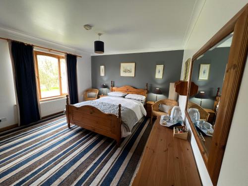 a bedroom with a bed and a large window at Carn A Chuilinn in Fort Augustus