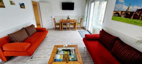 ein Wohnzimmer mit zwei roten Sofas und einem Tisch in der Unterkunft Dresden Großer Garten in Dresden