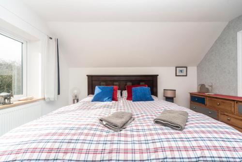 a bedroom with a large bed with blue and red pillows at 6 bedrooms beautiful home 3 bathrooms, quiet location with garden near Legoland Windsor Heathrow in Maidenhead