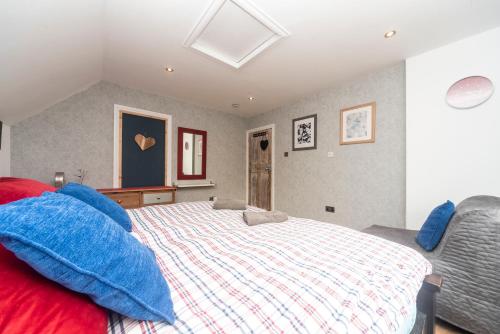 a bedroom with a large bed with blue pillows at 6 bedrooms beautiful home 3 bathrooms, quiet location with garden near Legoland Windsor Heathrow in Maidenhead
