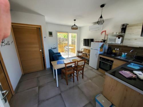 eine Küche und ein Wohnzimmer mit einem Tisch und Stühlen in der Unterkunft La casa Elisa Gîte T2 indépendant in Gréoux-les-Bains