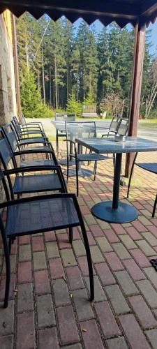 a group of picnic tables and benches on a patio at Domek w Lesie in Karłów