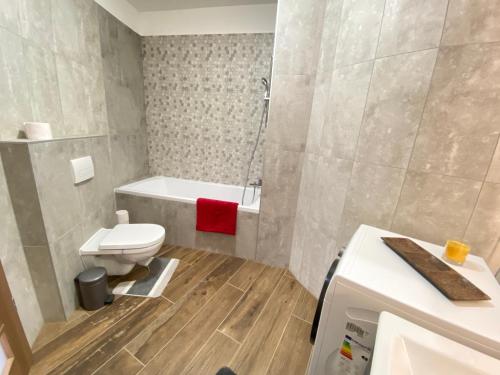 un baño con inodoro y bañera en Dandelion Royal Homes, en Keszthely