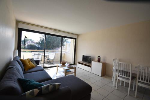 - un salon avec un canapé, une table et des chaises dans l'établissement Cap Marina - Capbreton proche port de plaisance appartement 4 personnes, à Capbreton