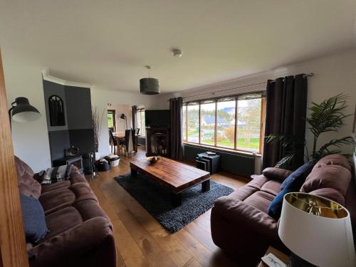 a living room with a couch and a coffee table at Carn A Chuilinn House in Fort Augustus