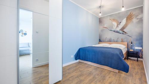 a bedroom with a bed and a painting of birds at Sagaris z basenem, Sun & Snow in Dziwnów