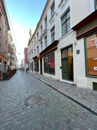 a cobblestone street in a city with buildings at Home Sweet Home in Rīga