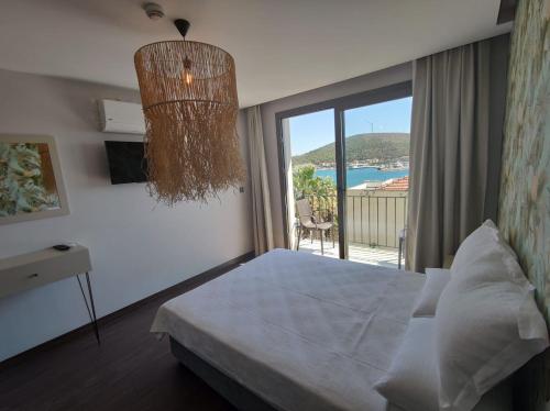 a bedroom with a bed and a large window at Eva Otel Çeşme in Cesme