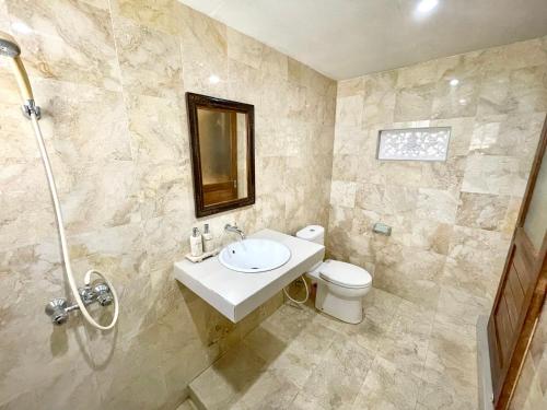 a bathroom with a sink and a toilet at DIMUWA Ubud in Ubud