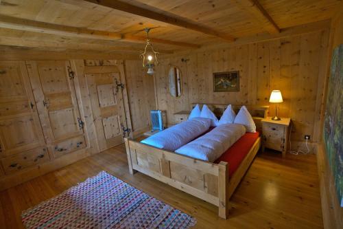 a large bed in a room with wooden walls at Chasa Sassalba in Lü