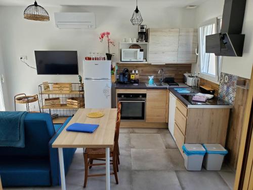 eine kleine Küche mit einem Tisch und einem Kühlschrank in der Unterkunft La casa Elisa Gîte T2 indépendant in Gréoux-les-Bains