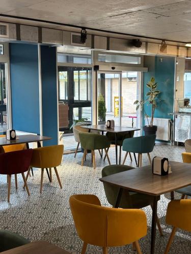 a restaurant with tables and chairs in a room at GOOD-VIBES Apartments in Batumi