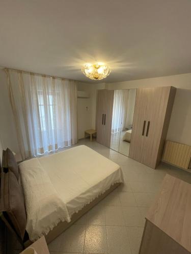 - une chambre avec un grand lit blanc et un lustre dans l'établissement Casa Vanni, à Cefalù