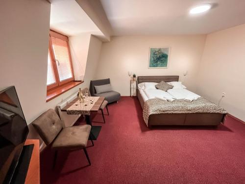 a bedroom with a bed and a chair and a table at Penzión Tavel in Prešov