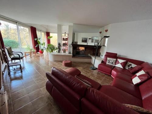 a living room with a red couch and a kitchen at Gazonfier in Le Mans