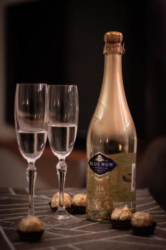 a bottle of wine and two glasses on a table at Penzión Tavel in Prešov