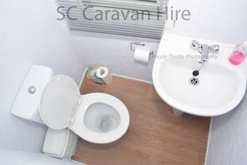 a bathroom with a white toilet and a sink at 3 Bedroom at Seton Sands Caravan Hire in Edinburgh