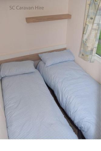 two beds sitting next to each other in a room at 3 Bedroom at Seton Sands Caravan Hire in Edinburgh