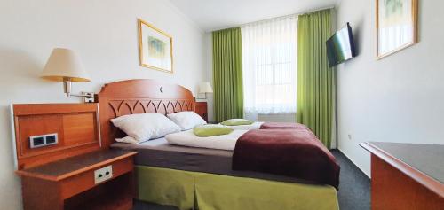 ein Schlafzimmer mit einem großen Bett mit einem Kopfteil aus Holz in der Unterkunft Gasthof Alte Schule in Fürstenzell