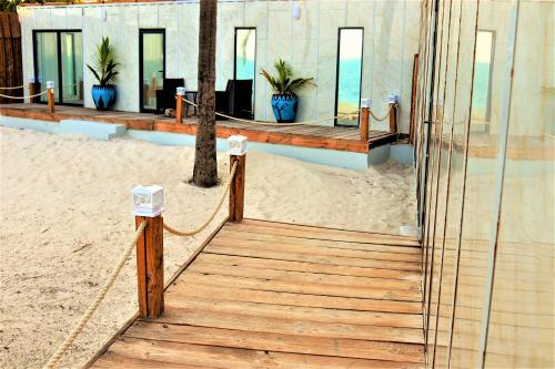 una passerella in legno che conduce a un edificio sulla spiaggia di The Zanzibar Beach House-West a Pingwe