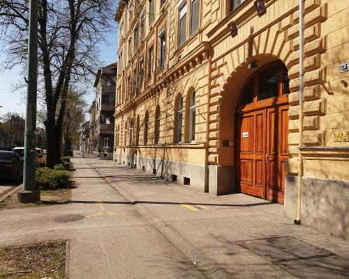 a building with a wooden door on the side of a street at Hanna apartman in Szeged