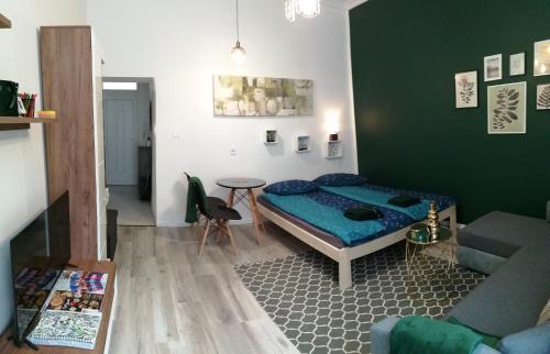 a bedroom with a bed and a table and a couch at Hanna apartman in Szeged
