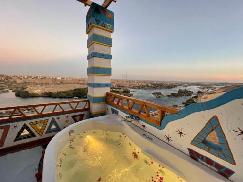 a bath tub on a balcony with a view of a river at Kato Dool Wellness Resort in Aswan