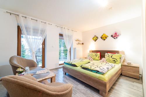 a bedroom with a bed and two chairs at Penzión Zunama in Bardejovské Kúpele