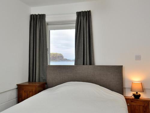 a bedroom with a bed and a large window at Generals Yard in Eyemouth