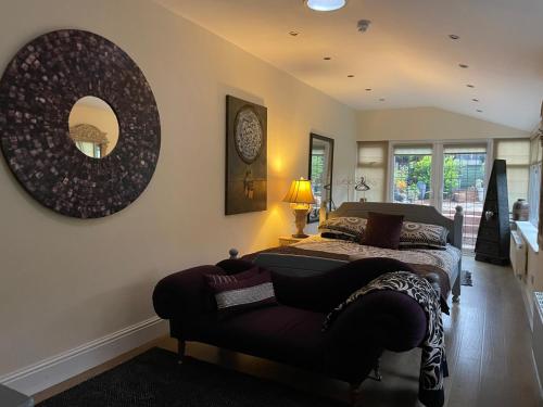 The Vines Lodge luxury apartment في كْليثوربس: غرفة نوم بسريرين ومرآة على الحائط