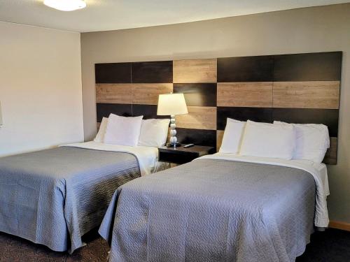 una habitación de hotel con 2 camas y una lámpara en Woodland Inn, en Niagara Falls